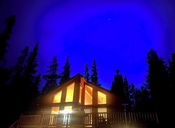 A cabin with a wooden exterior, large windows, and a porch.