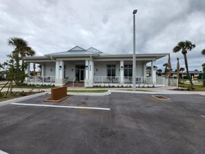 A modern building with a flat roof, large windows, and a covered entrance area. - Ocean Village Vacation Rental, Golf view. Short walking distance to the beach.  (Hutchinson Island)