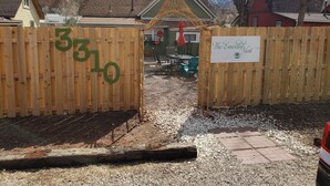 A gated entrance with a wooden fence marked with the number 3310, leading to a property named "The Emerald Nest."