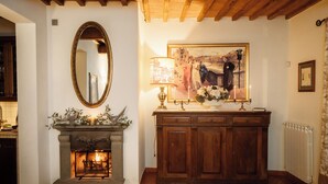 Una habitación con chimenea, un armario de madera y un cuadro en la pared.