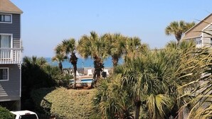 Un barrio residencial con vista al océano, palmeras y una piscina.