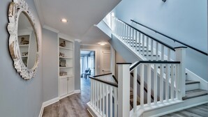 A staircase with white railings and a wooden floor, leading to a second floor.