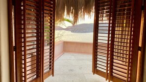 Ein Zimmer mit Holzhörnern und Blick auf einen Strand.