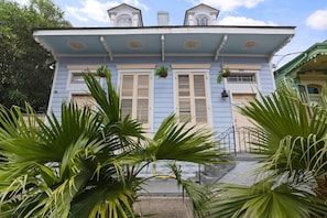 A two-story building with a balcony and a small porch area.