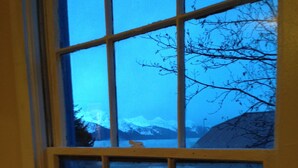 A window with a view of a snowy mountain landscape. - The 1905 Government. cable Office: Historic Charm, views, location Downtown (Seward)