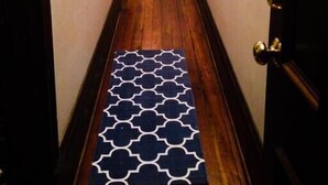 A narrow hallway with wooden flooring and a patterned rug. - Big Blue House - Lower Unit - Near Forsyth Park - Sleeps 8 (Savannah)