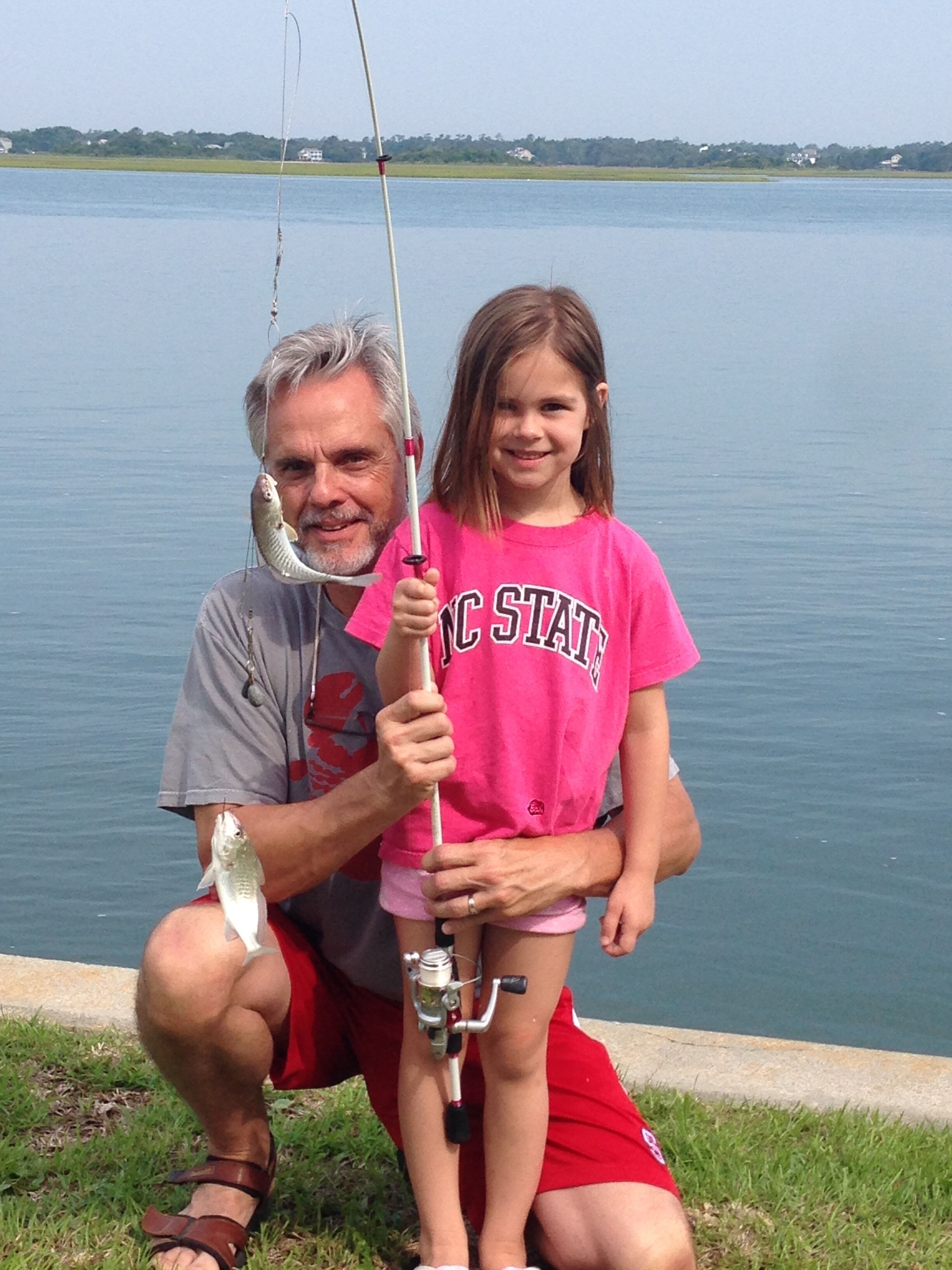A man and a child fishing by a lake.