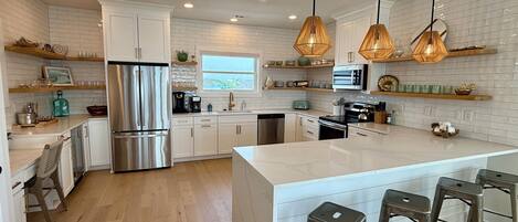 Fully stocked luxury kitchen with ocean views out of the window.