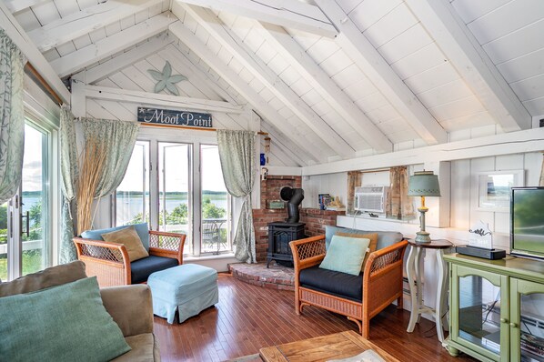 A cozy room with wicker furniture, a fireplace, and a view of the outdoors.