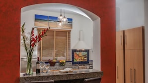 A kitchen with a granite countertop, a stove, and a window with blinds. - Great Location - Just steps from Mamitas Beach and Fifth Avenue ~ Special Rates  (Playa Del Carmen)