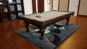 Enjoy a game of pool in this stylish room with a billiards table and comfortable seating.
