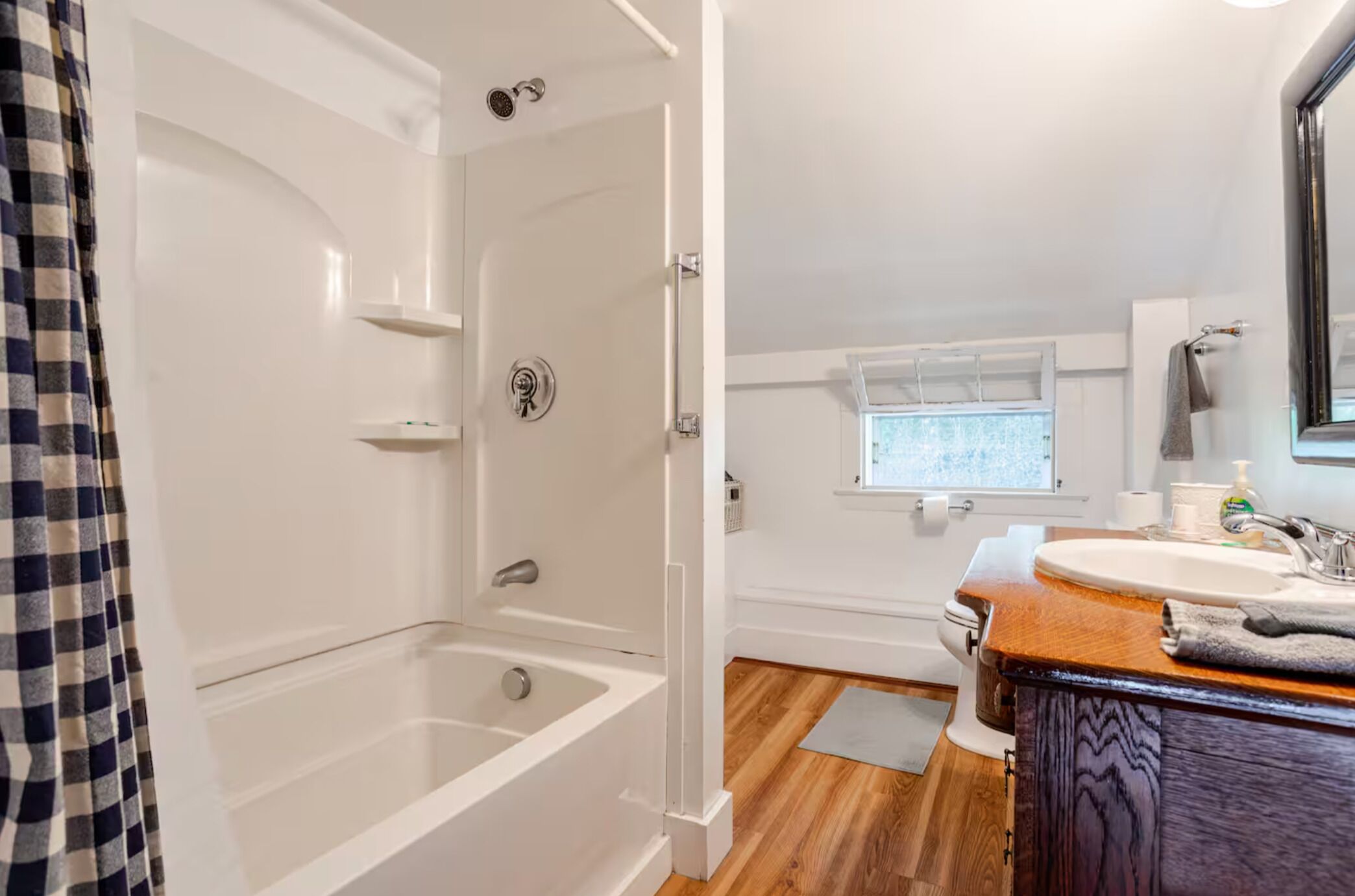 Une salle de bain avec une baignoire, un lavabo et une fenêtre.
