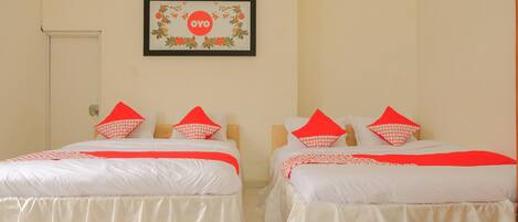 Two twin beds with white bedding and red accents, a framed artwork on the wall, and a door to the left.