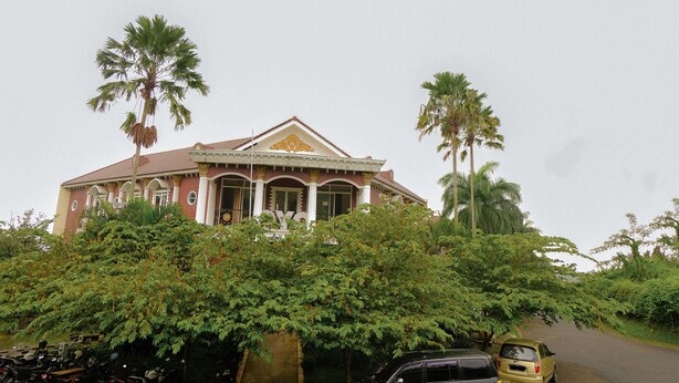 A large, colonial-style building with a symmetrical facade, multiple windows, and a central entrance. - OYO Life 414 Loji Rejo Guest House (Malang)