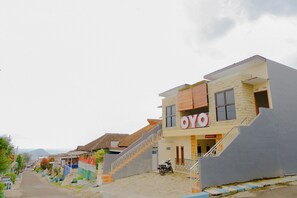 Un bâtiment moderne avec une enseigne indiquant « OYO » et un escalier menant à l’entrée.