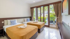 A hotel room with two beds, a TV, and a large window with curtains. - Dewi Villa Padangbai Hotel (Padangbai)