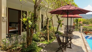 A hotel with a pool, outdoor seating, and lush greenery. - Dewi Villa Padangbai Hotel (Padangbai)