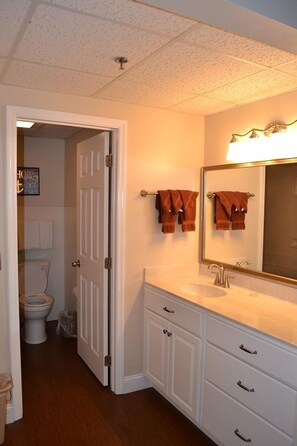 A bathroom with a white vanity, a large mirror, and two towels hanging on the wall. - Attractive 504 2BD Condo with Private Balcony and Jacuzzi Tub by RedAwning (Pigeon Forge)