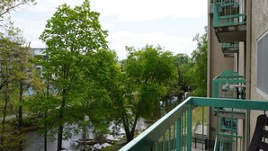 Ein Gebäude mit einer grünen Treppe, einem Fluss und Bäumen.