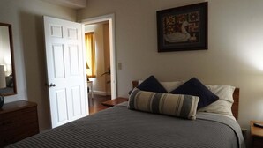 A bedroom with a bed, a nightstand, a dresser, a door, and a framed picture on the wall. - Little Pigeon River 508 2BD Condo with Fireplace and Jacuzzi Tub by RedAwning (Pigeon Forge)