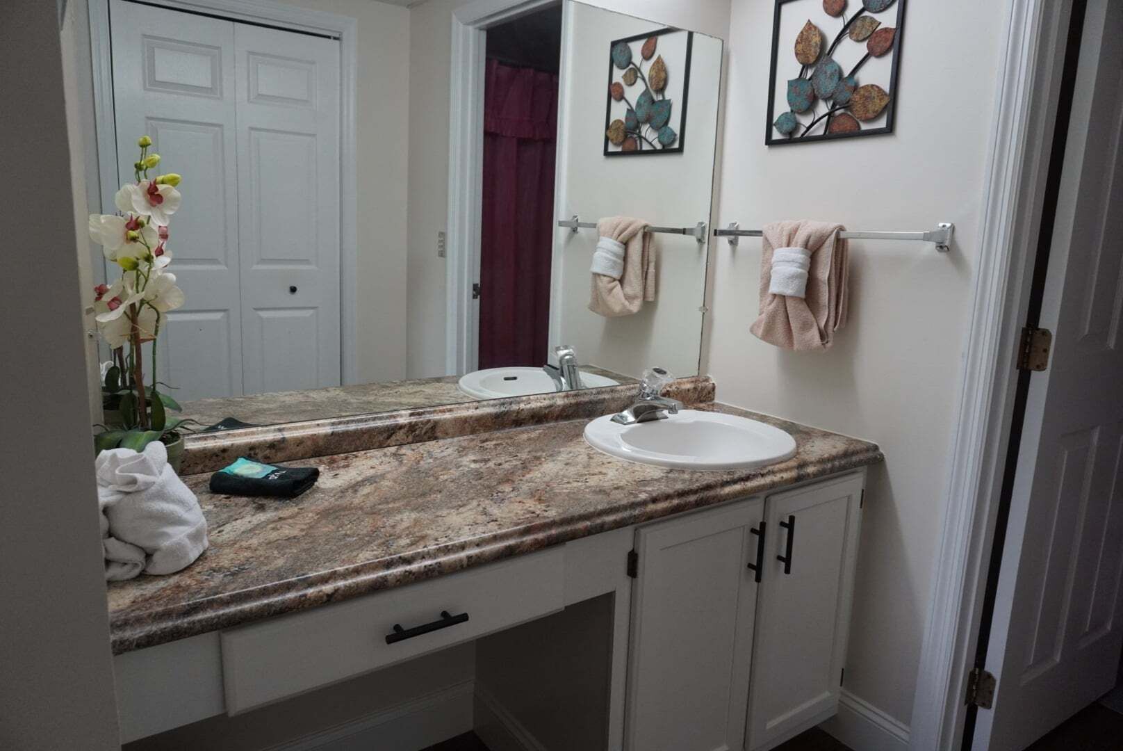 A bathroom with two sinks, a mirror, and a towel rack.