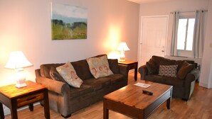 A living room with two sofas, a coffee table, and two lamps. - Little Pigeon River 602 2BD Condo with Private Balcony by RedAwning (Pigeon Forge)