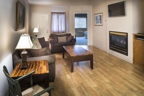 Ein Wohnzimmer mit einer Couch, einem Holztisch, einer Lampe und einem Kamin.
