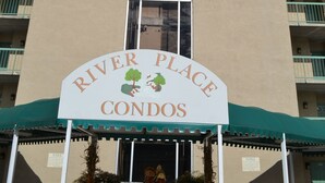 A building with a sign reading "River Place Condos". - Little Pigeon River 602 2BD Condo with Private Balcony by RedAwning (Pigeon Forge)