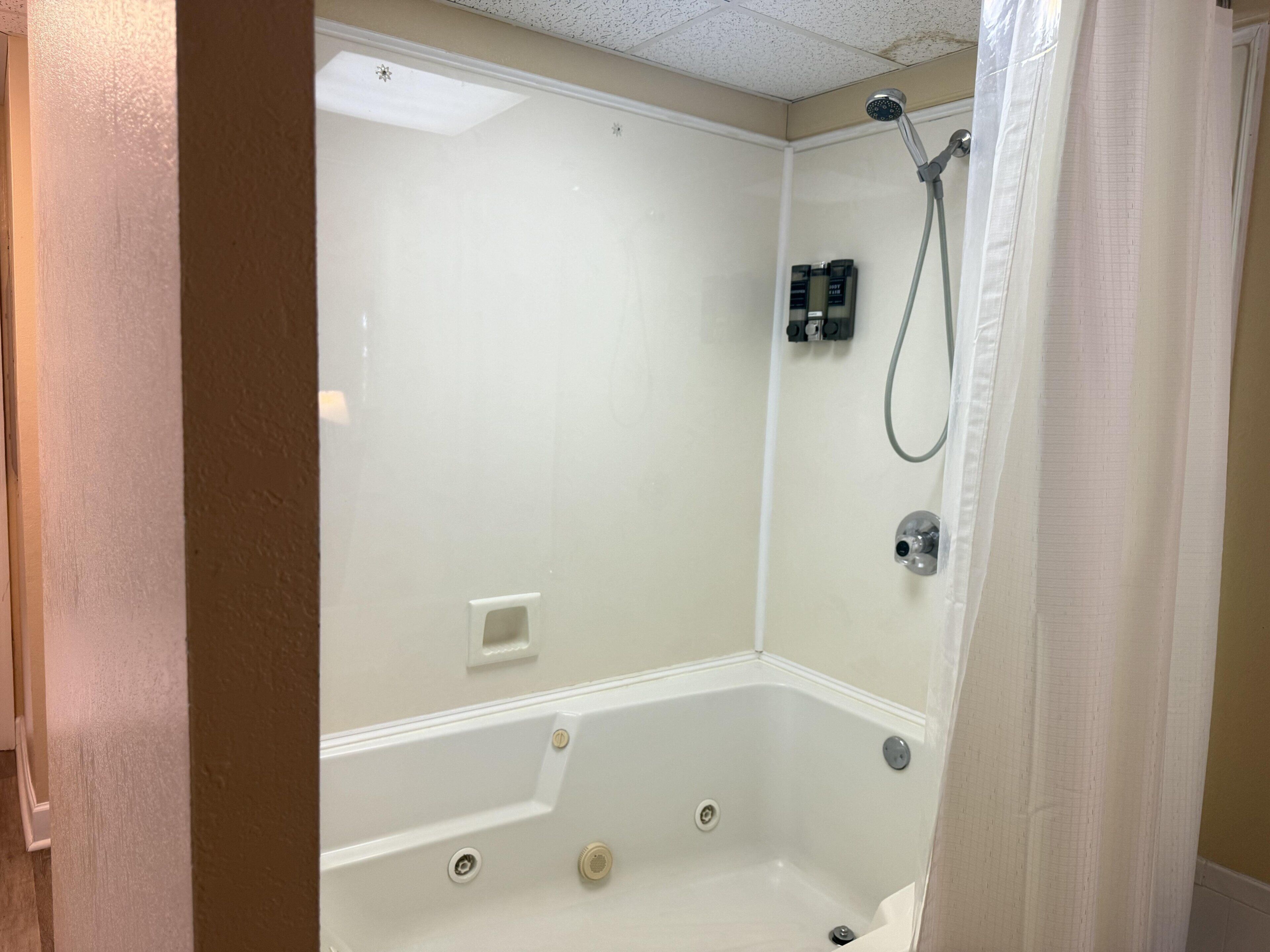 A bathroom with a bathtub, shower, and a toilet.