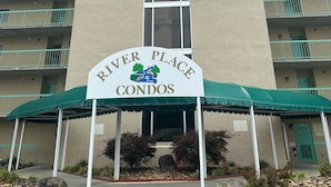 A multi-story building with a sign reading "River Place Condos". - 409 1bd 1 Bedroom Condo by RedAwning (Pigeon Forge)