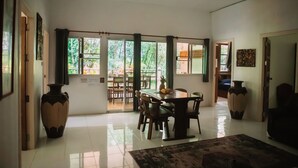 A spacious dining area with a large table and chairs, a decorative rug, and two large vases.