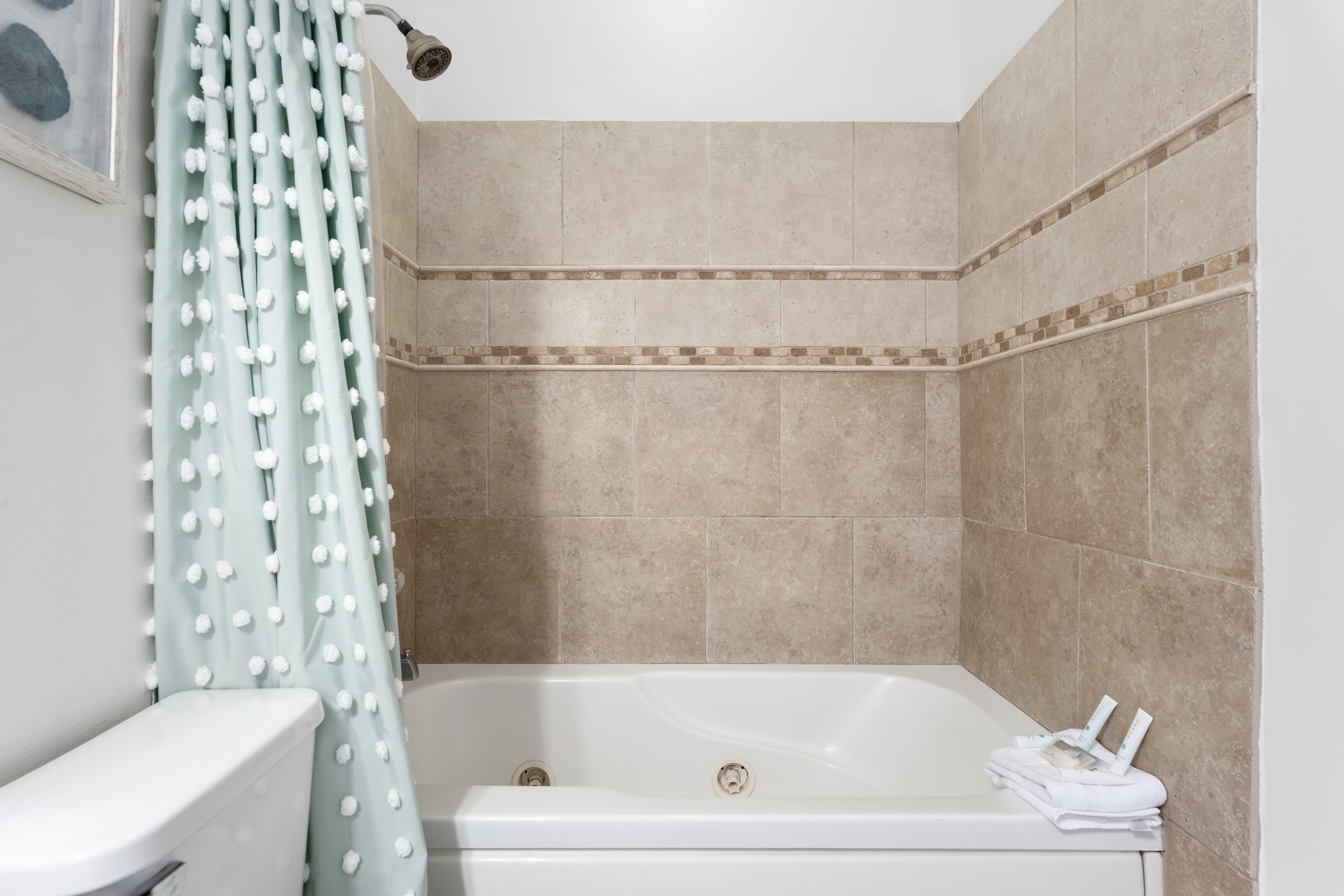 Een badkamer met een bad, toilet en douchegordijn.