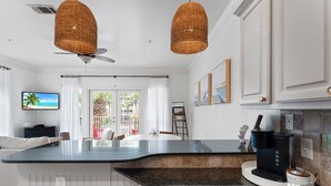 A modern kitchen with a large island, a coffee maker, and a view of the outdoors. - Crystal Beach. Caribbean Dunes. Completely Renovated. Corner Unit. Gulf View.  (Destin)