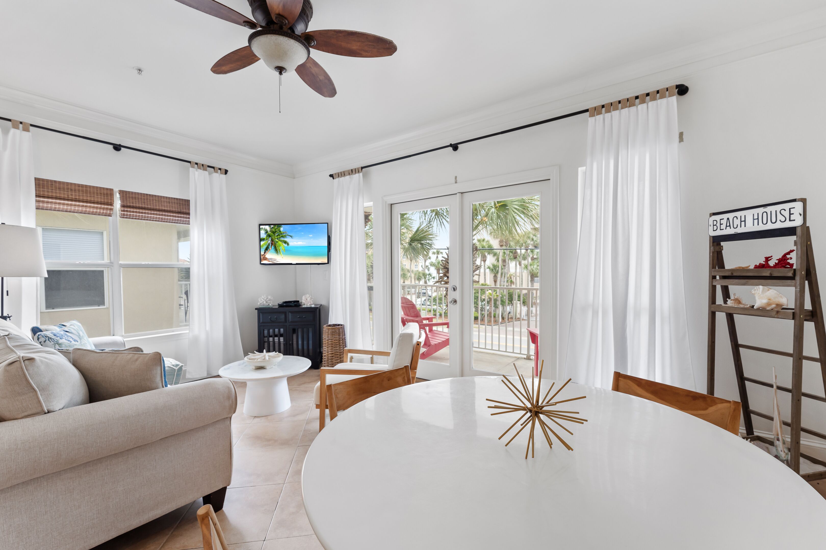 A living room with a sofa, a coffee table, a TV, and a dining table with chairs.