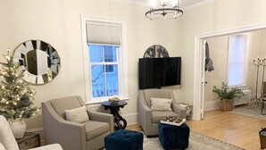 A living room with two sofas, a coffee table, a TV, and a Christmas tree. - Spacious home w/Hot Tub near Lake Superior walk to restaurants, breweries, beach (Marquette)