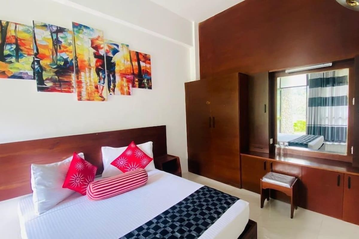 Une chambre d’hôtel avec un lit, une armoire, un miroir et des œuvres d’art accrochées au mur.