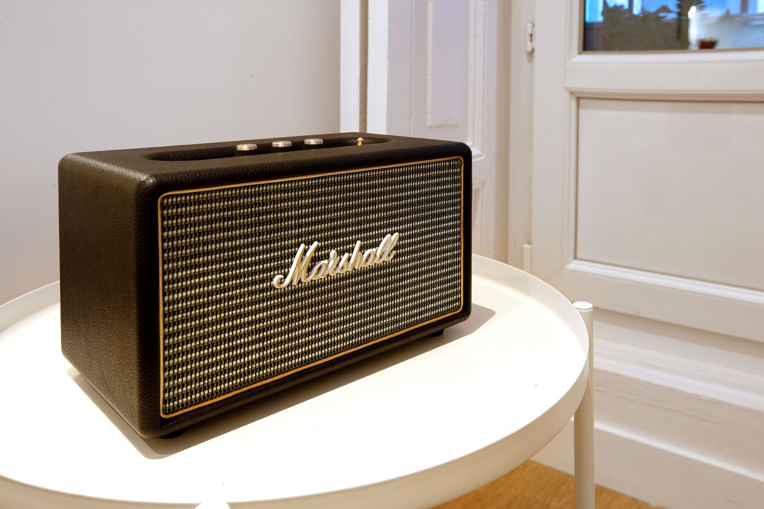 A Marshall amplifier on a white table.