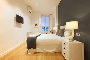 Ein modernes Hotelzimmer mit einem großen Bett, Nachttischen, einem Flachbildfernseher und einem Fenster mit Blick.