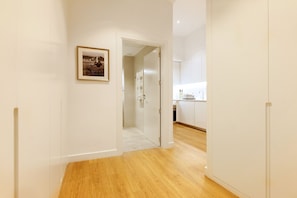Un pasillo con piso de madera que conduce a una zona de cocina.