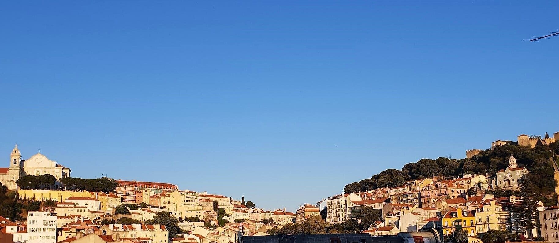 Une ville pittoresque, construite à flanc de colline, avec des bâtiments historiques et une église imposante.