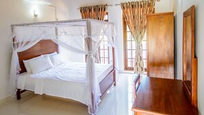 Un dormitorio con techo de madera, una cama con dosel, una mesa de madera y una ventana con cortinas.