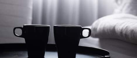 Dos tazas negras sobre una bandeja redonda negra.
