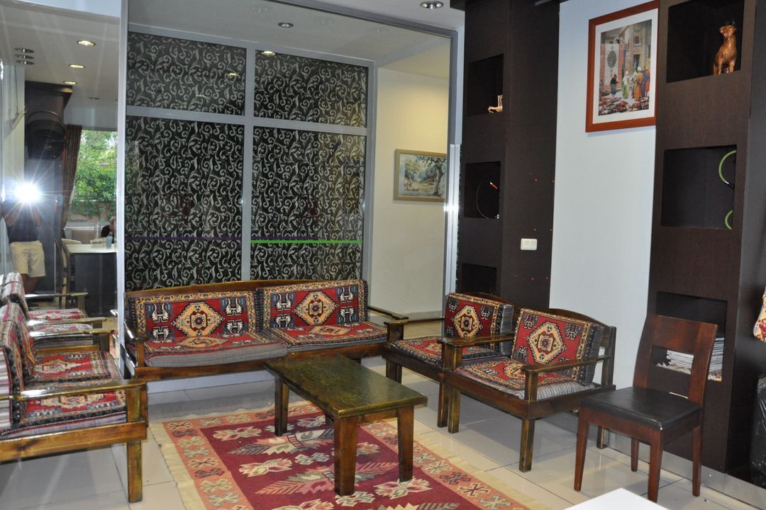 Une pièce au décor traditionnel, avec des canapés à motifs, une table basse en bois et un tapis décoratif.