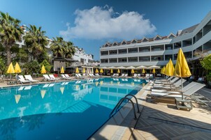 Una piscina techada, una piscina al aire libre, sombrillas