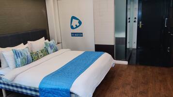 Una habitación de hotel con una cama, una puerta con un letrero y un pasillo.