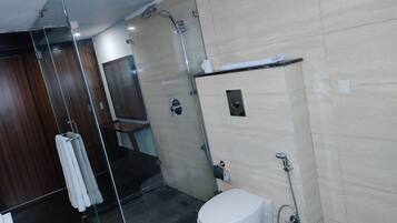 Un baño moderno con cabina de ducha de vidrio, inodoro y lavabo.