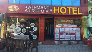 The exterior of Kathmandu Airport Hotel with a clear view of the entrance and a signboard listing various airlines. - Kathmandu Airport Hotel (Kathmandu)