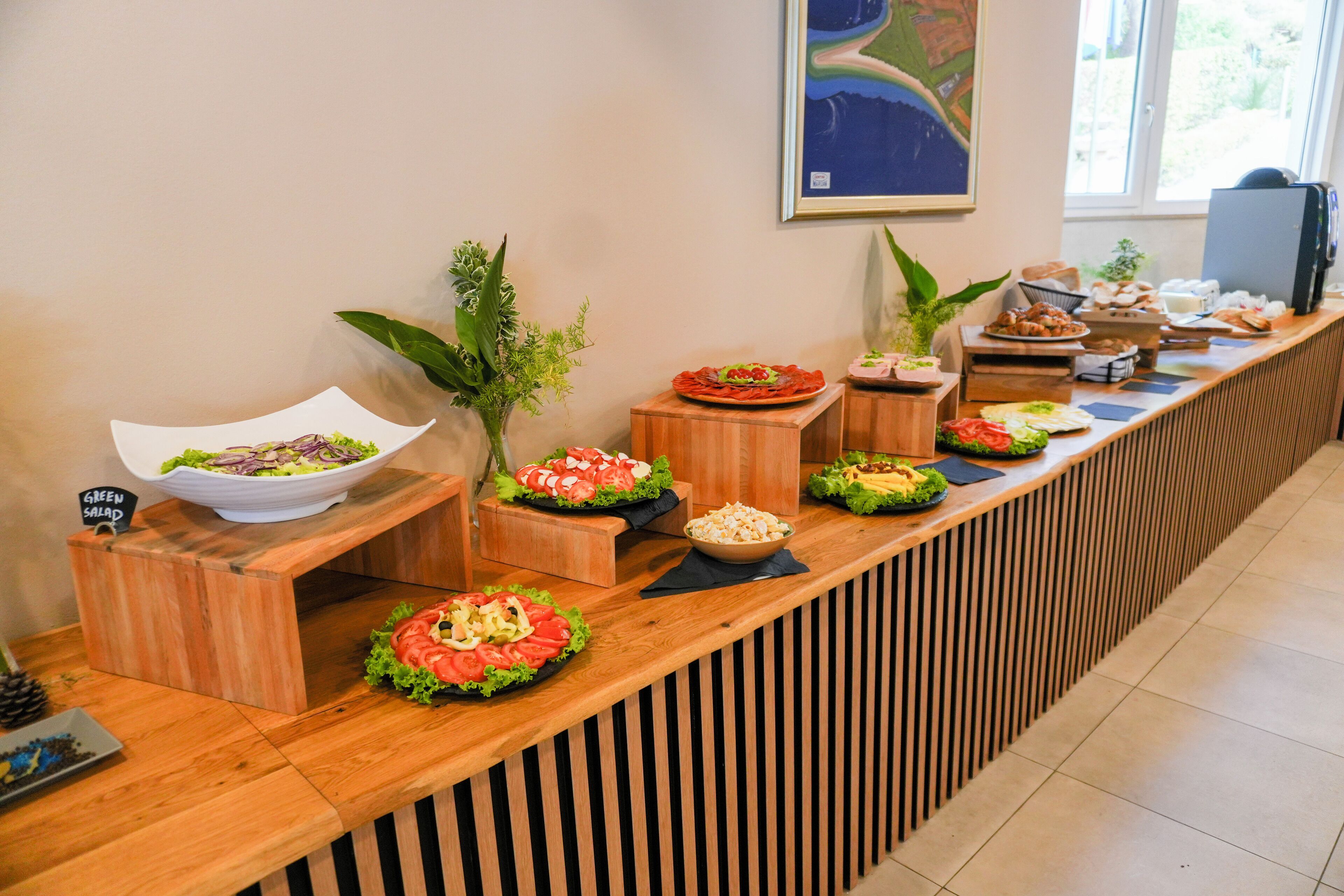 Een buffetopstelling met diverse gerechten en een bordje met de tekst 'Groene Salade'.