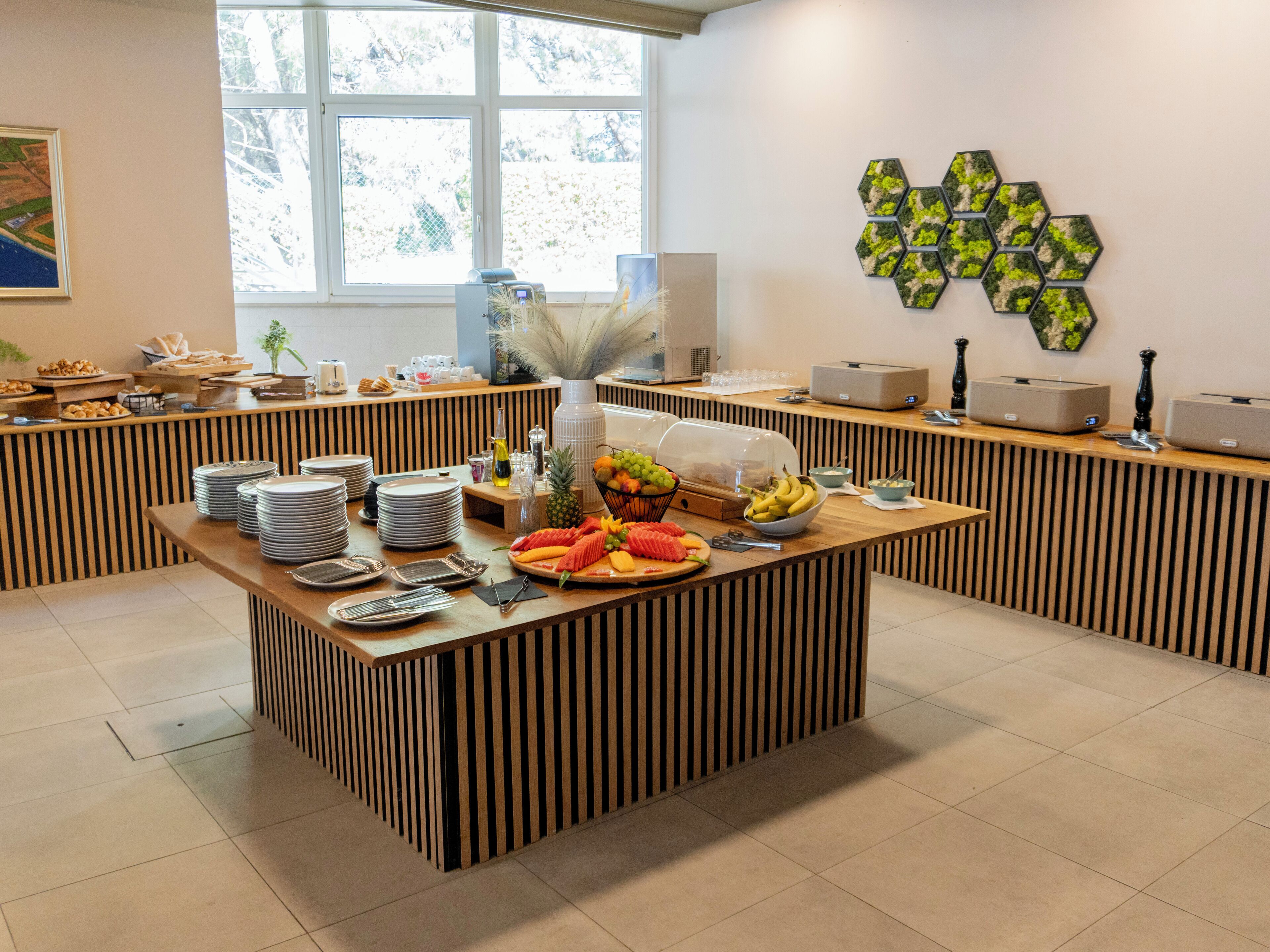 A buffet setup with various food items and a decorative wall piece.