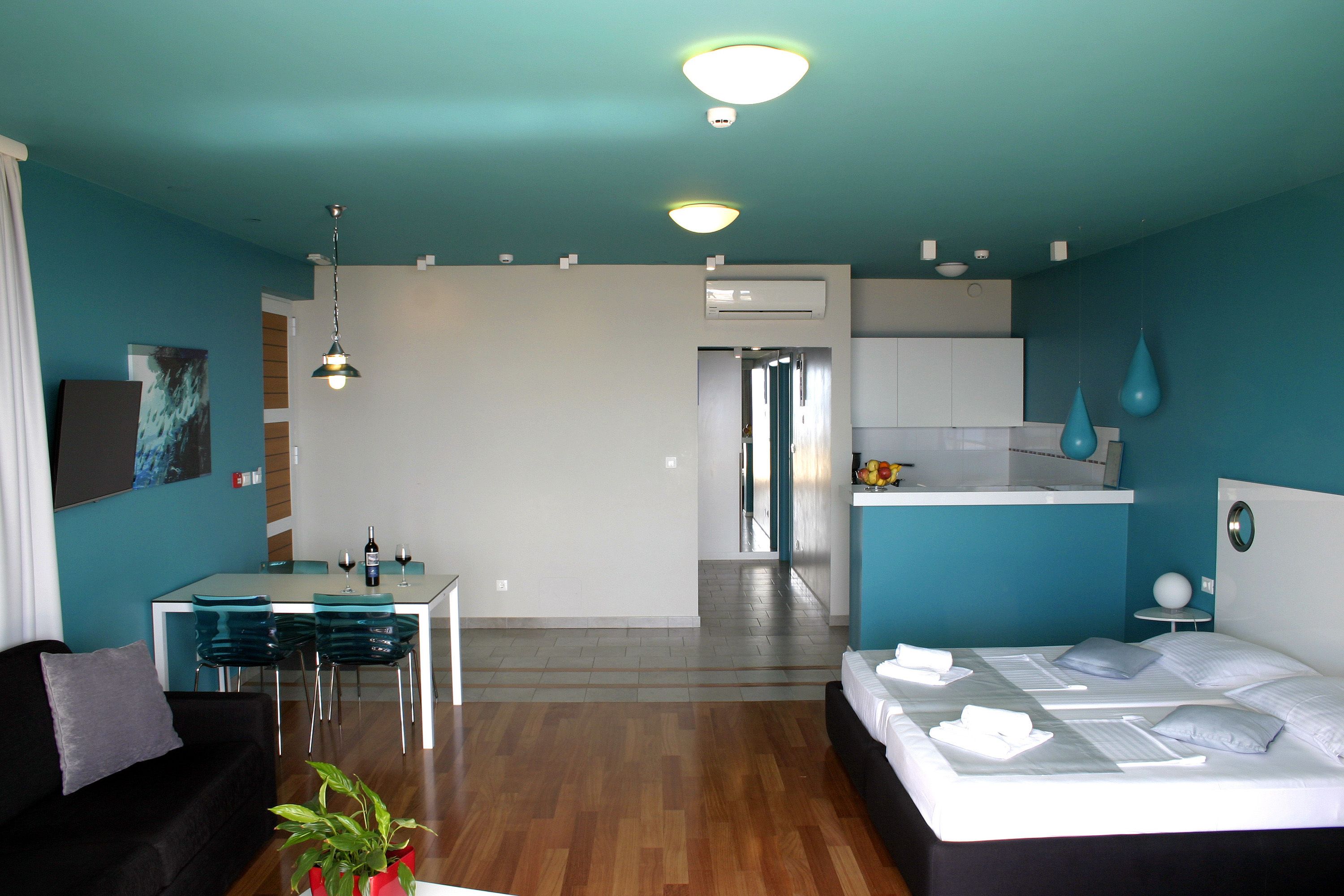 Una habitación de hotel moderna con cama, zona de comedor y cocina.